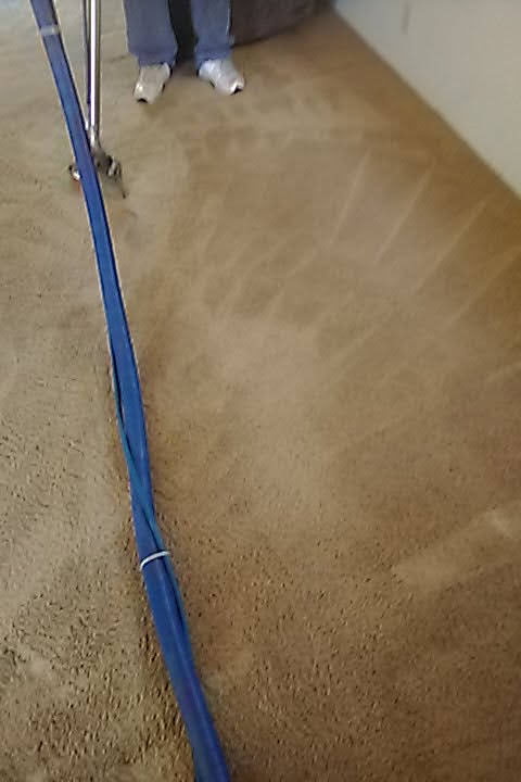 Tan carpet with a cleaning wand and hose, one side lighter than the other