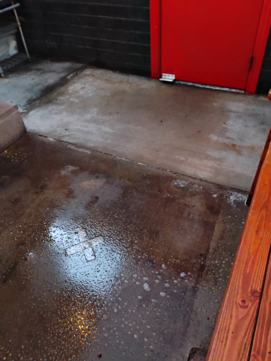 A concrete entry area with a lighter section and a wet, soapy section