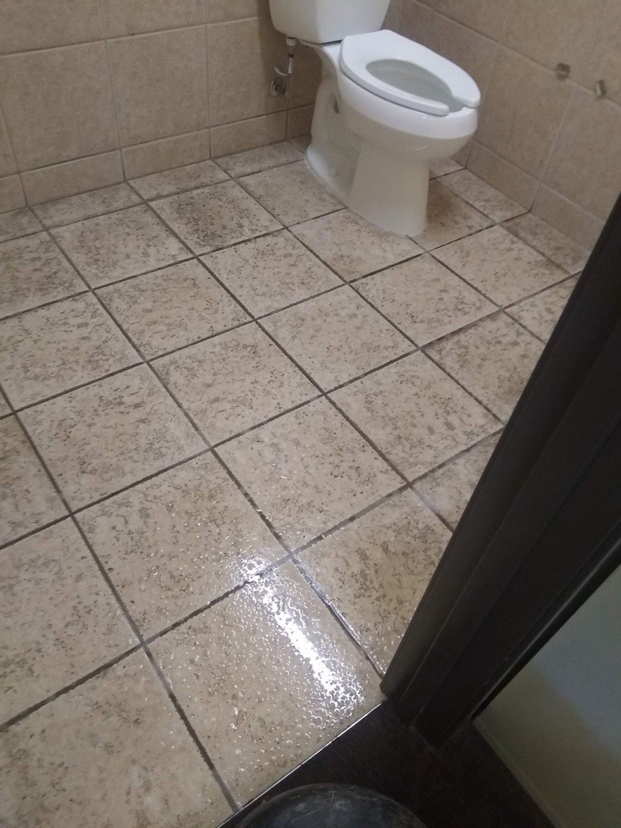 A restroom tile floor with clean grout after cleaning