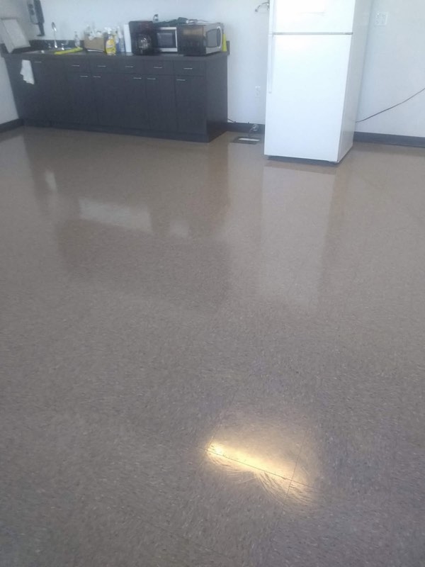 A shiny, freshly cleaned tile floor in an office break room